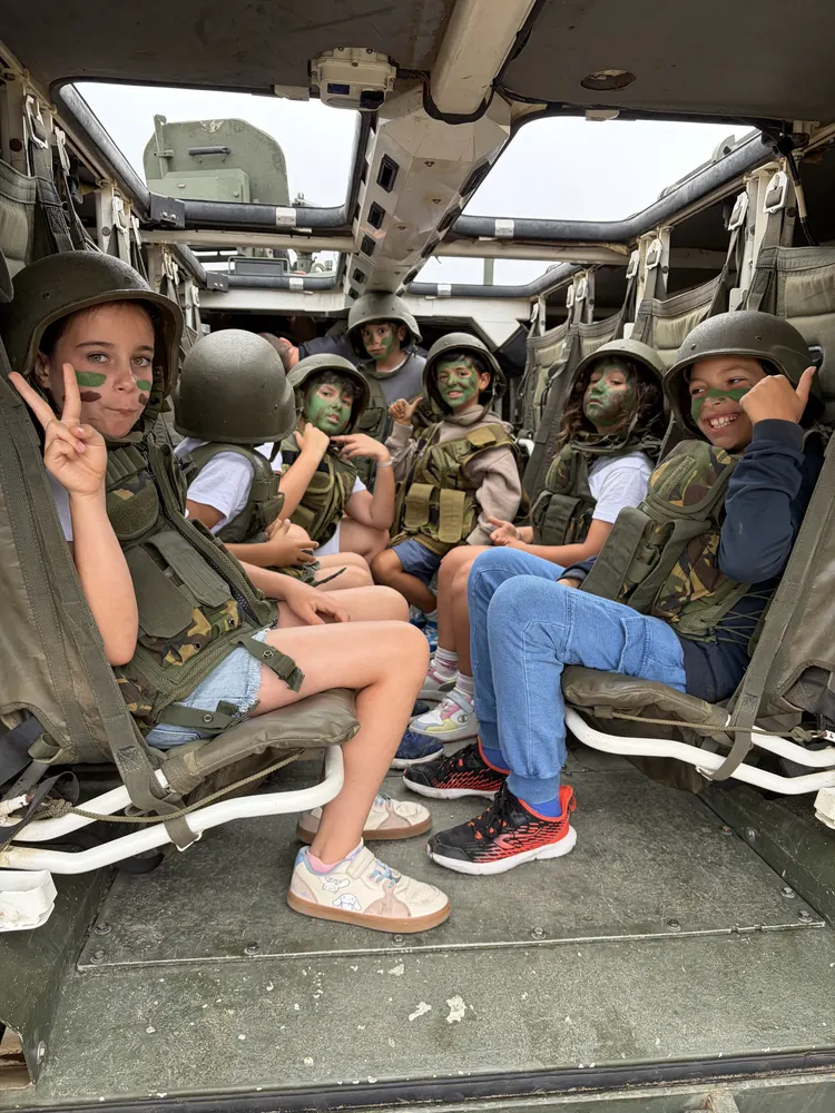 Crianças dentro de uma viatura militar, no Regimento de Engenharia