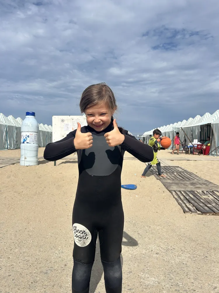 Criança de fato de surf, pronta para entrar na água