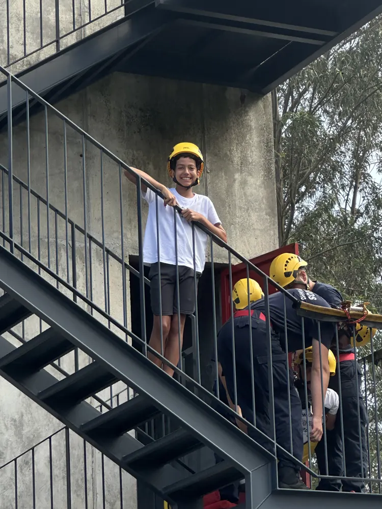 Crianças de capacete a preparar a descida em rapel