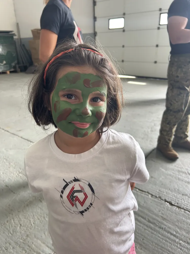 Menina com pintura facial de camuflagem