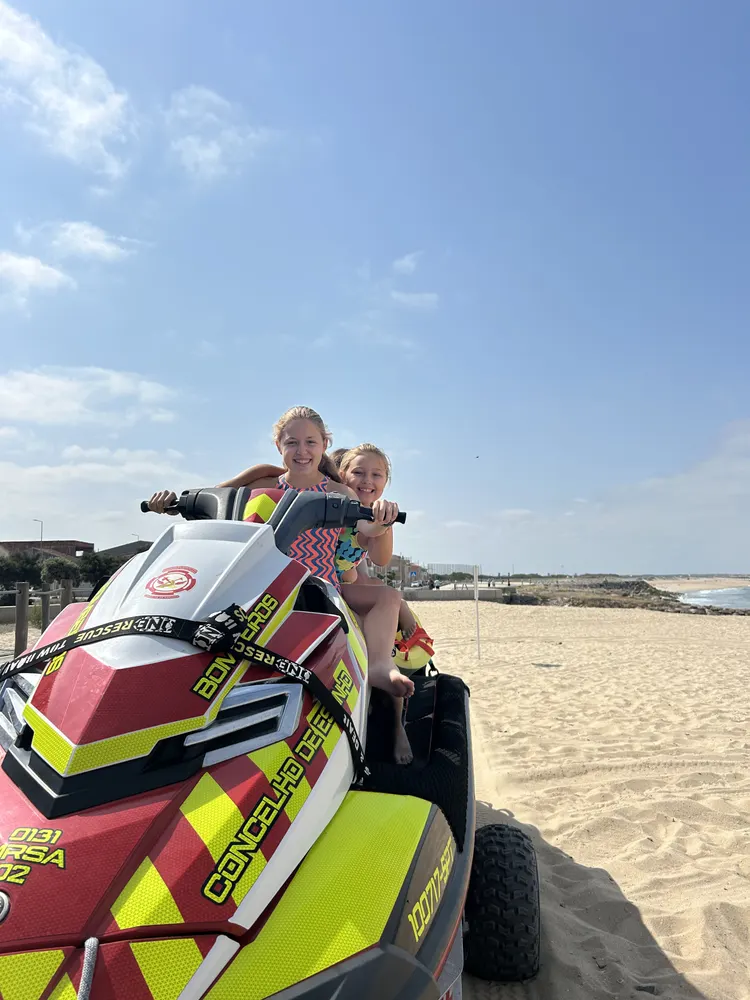 Crianças na mota de água dos bombeiros, na praia