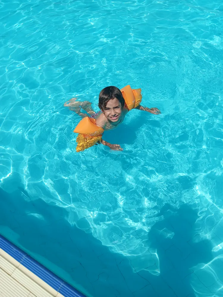 Criança a nadar na piscina